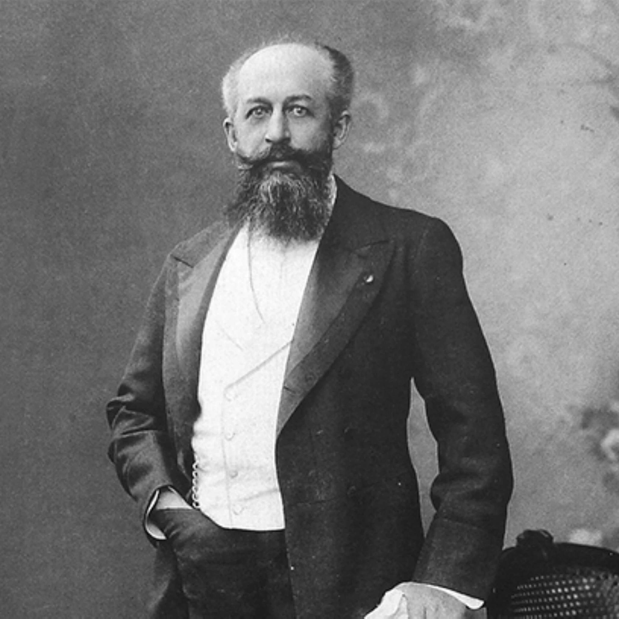 Portrait Nagelmackers d'un homme barbu debout en costume formel dans un studio du XIXe siècle