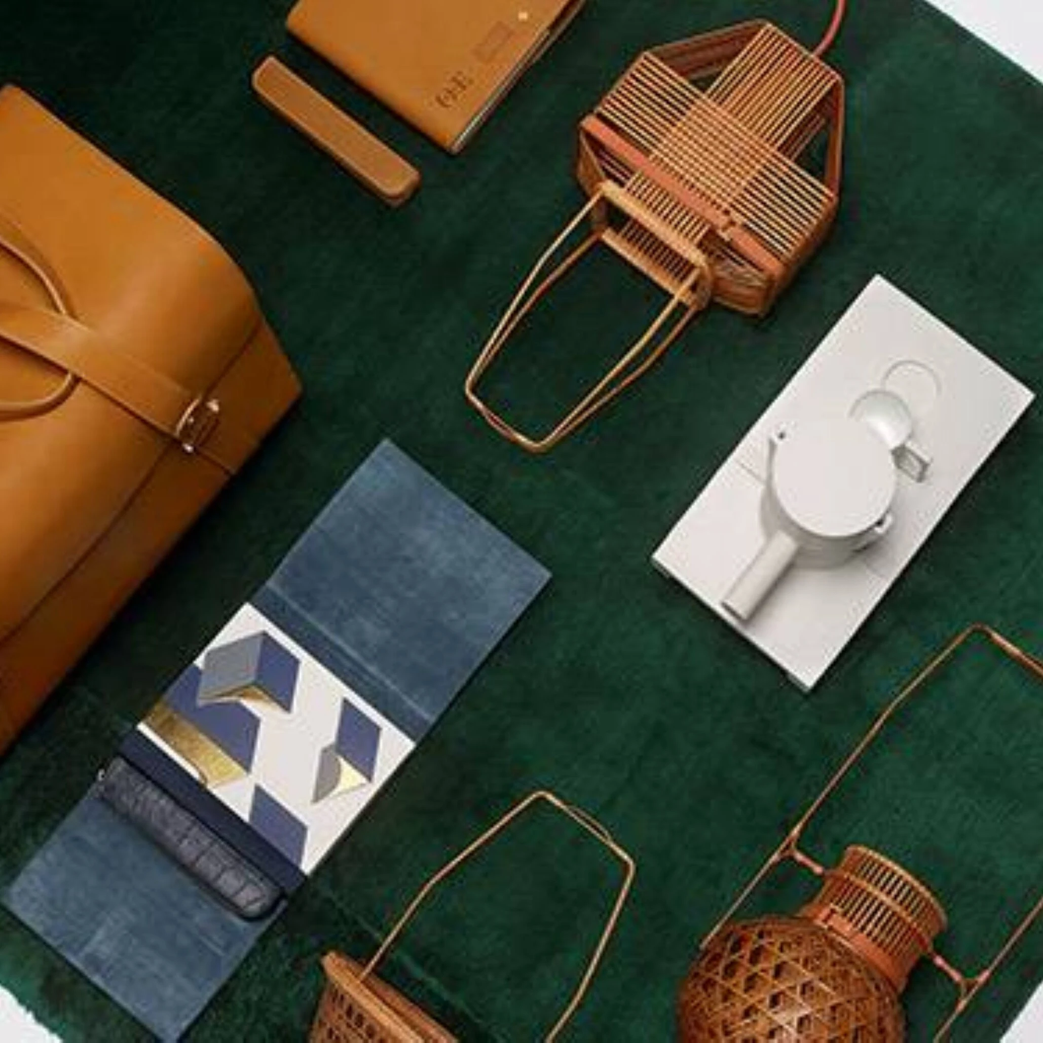 Orient Express sac week-end en cuir et accessoires de voyage disposés sur un velours vert foncé