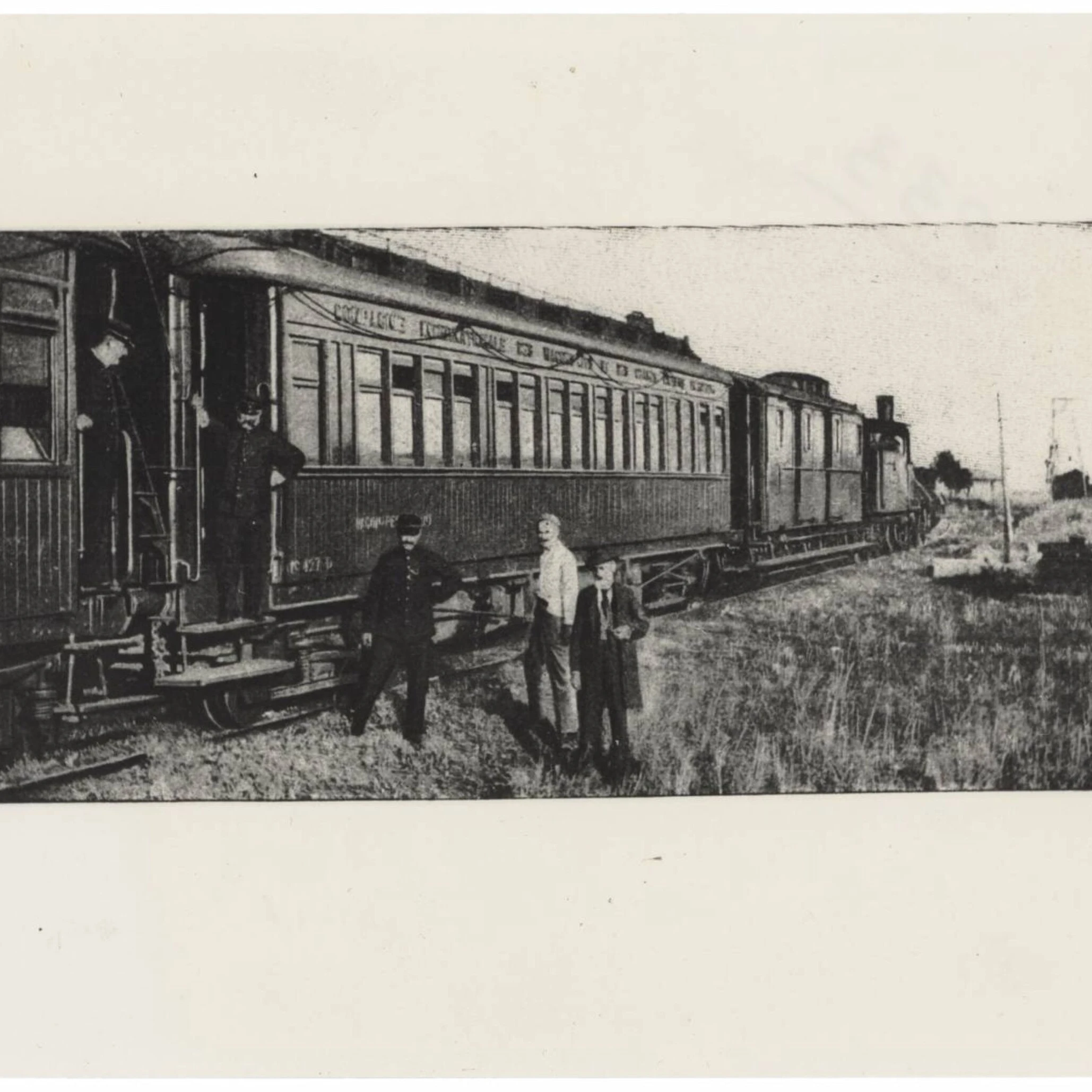 Orient Express — hommes et personnel debout près d'une voiture vintage sur voie rurale en noir et blanc historique